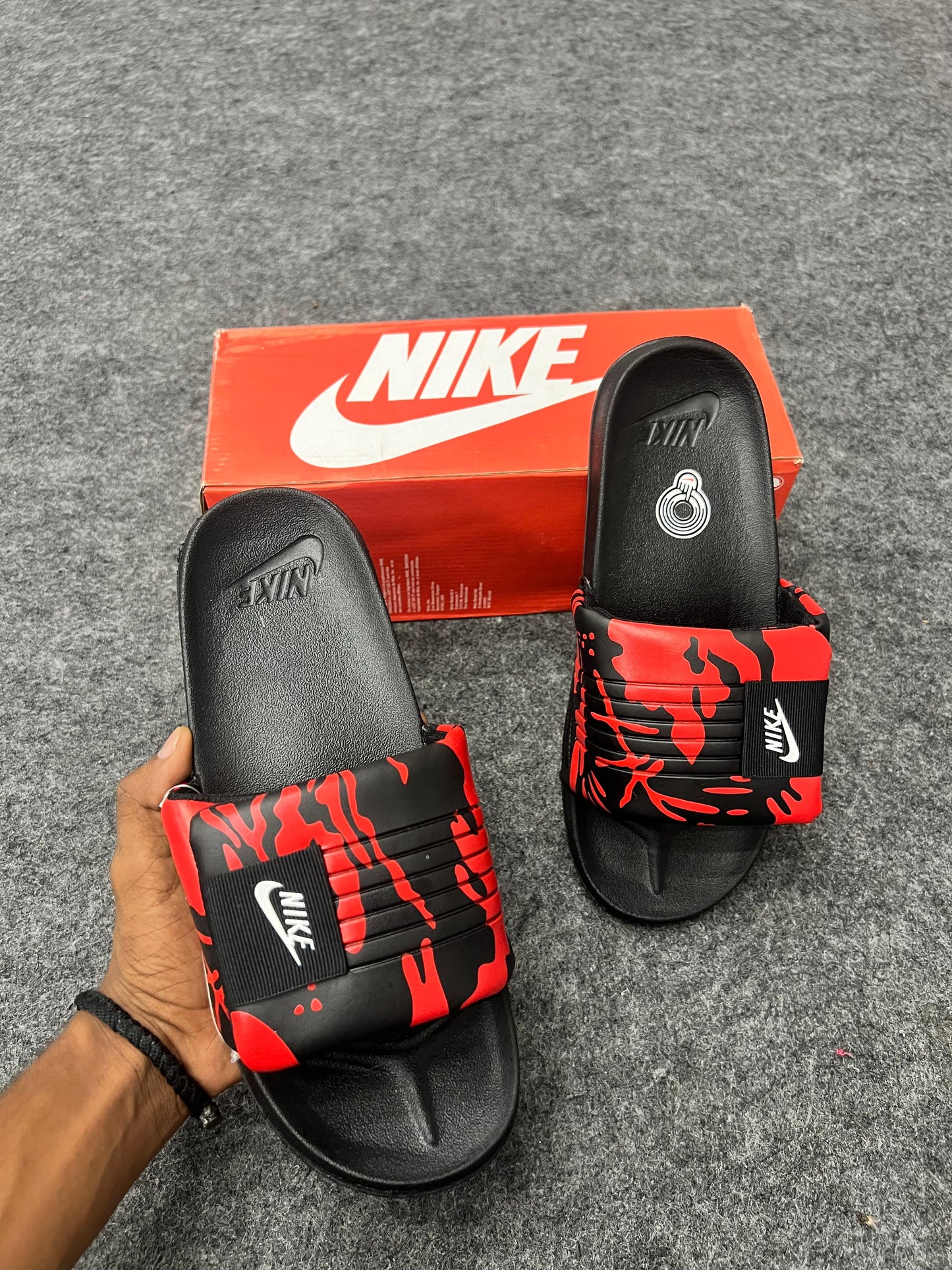 Bold Nike slides with a red and black strap