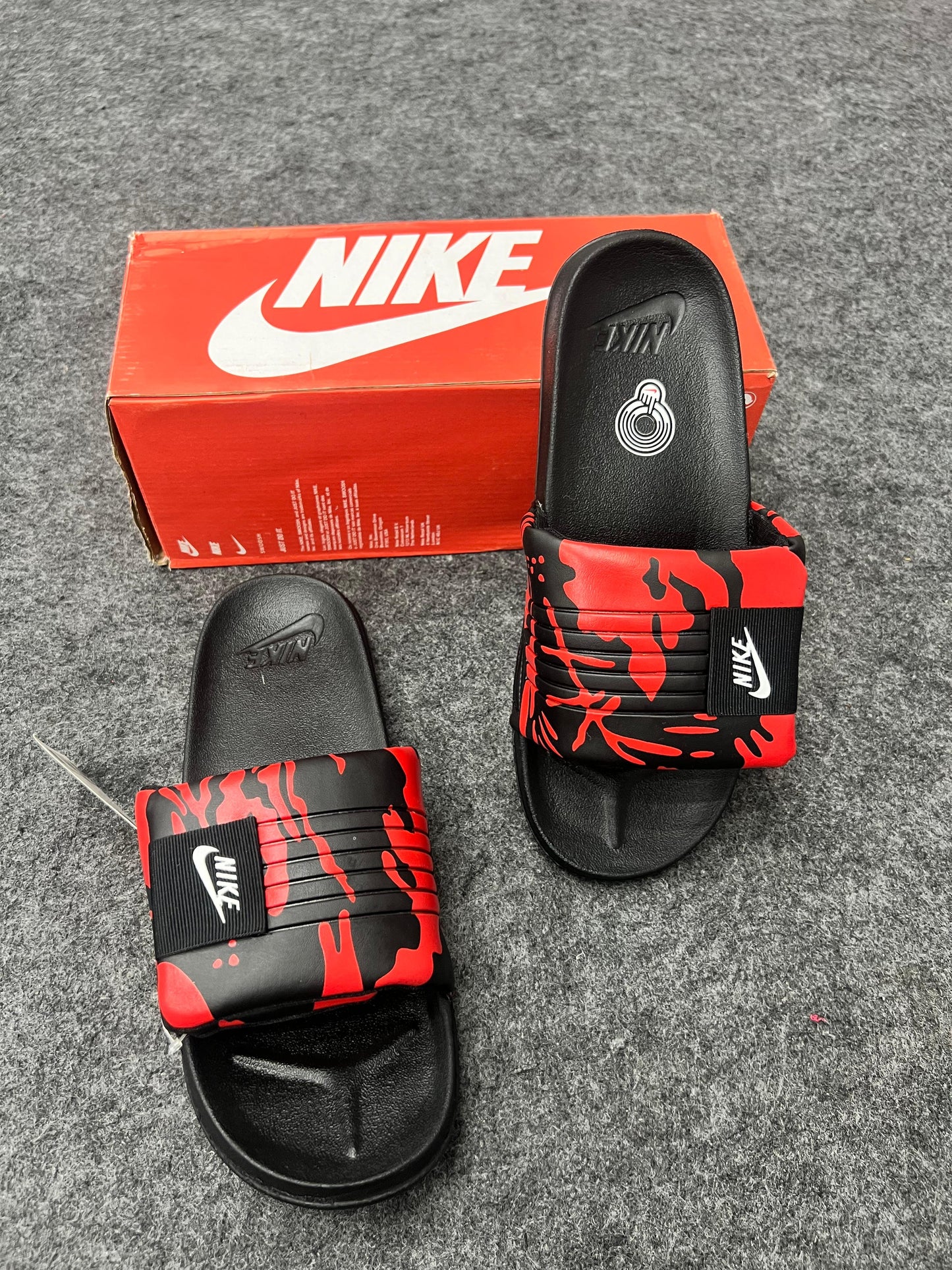 Bold Nike slides with a red and black strap