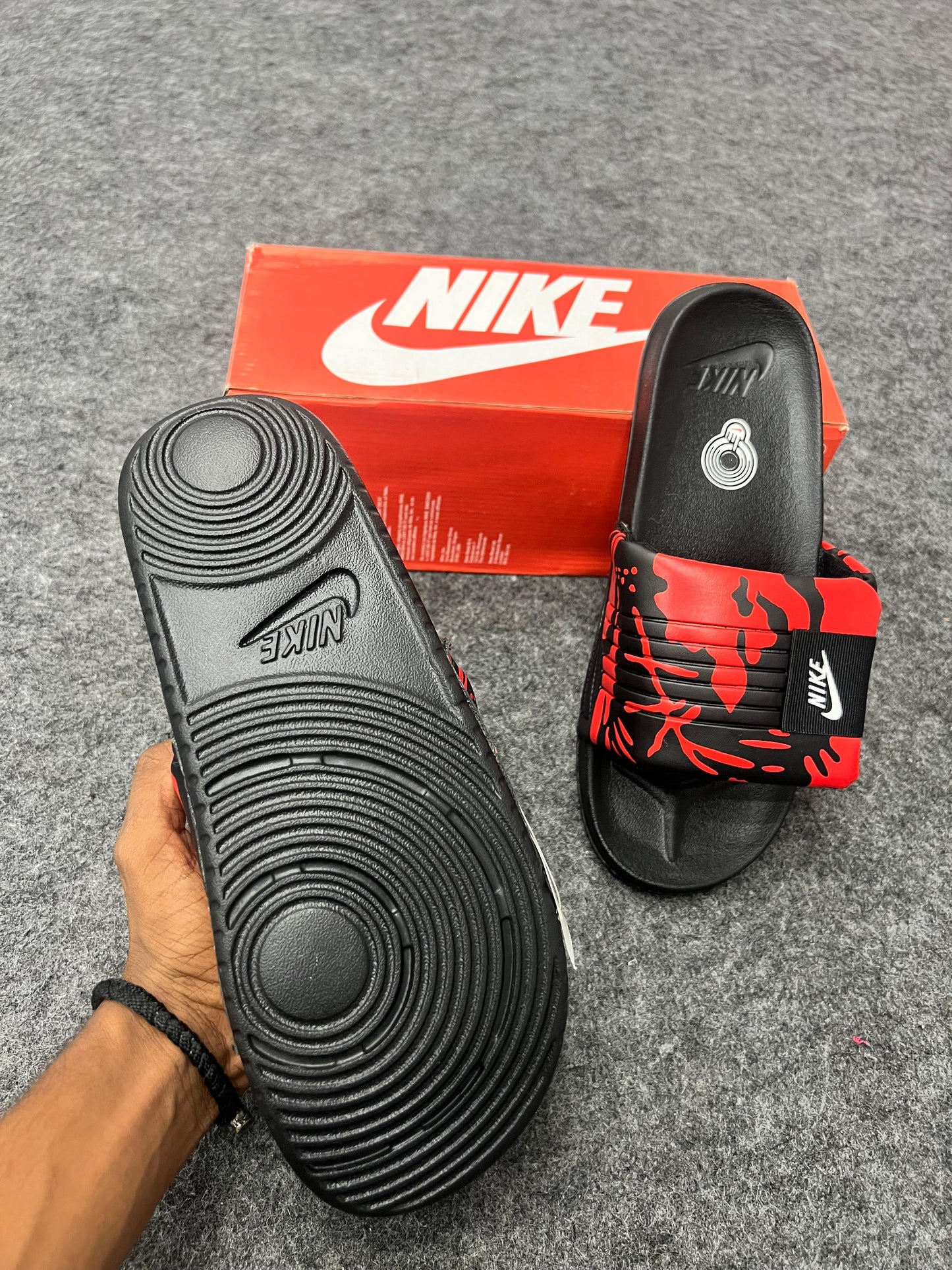 Bold Nike slides with a red and black strap