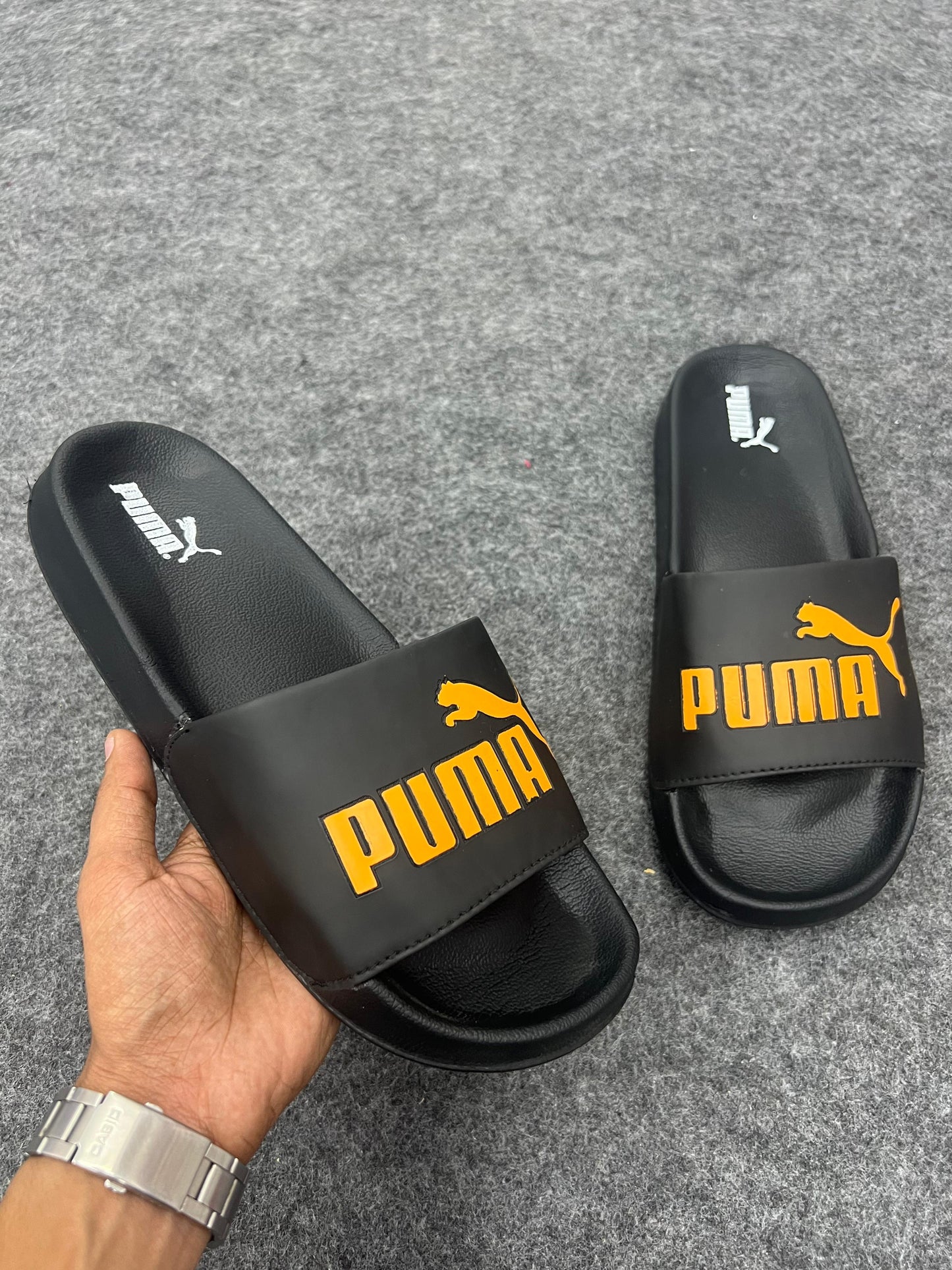 Black Puma slides with a bold yellow logo.