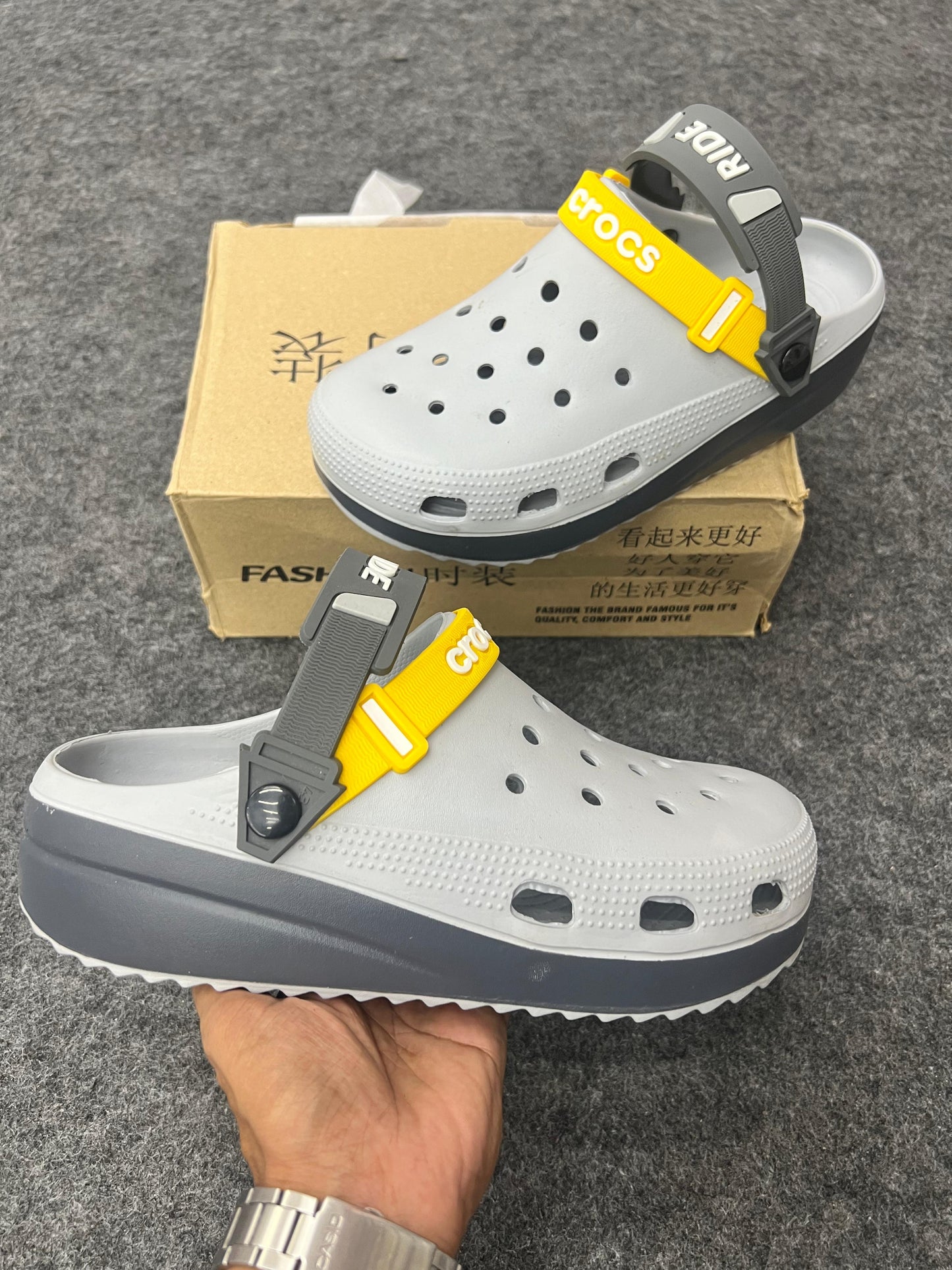 Grey Crocs featuring bold yellow and dark grey straps.