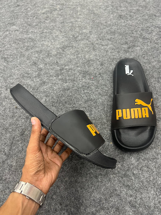Black Puma slides with a bold yellow logo.