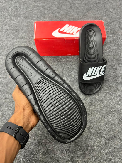 bold white logo for a sharp black Nike slides