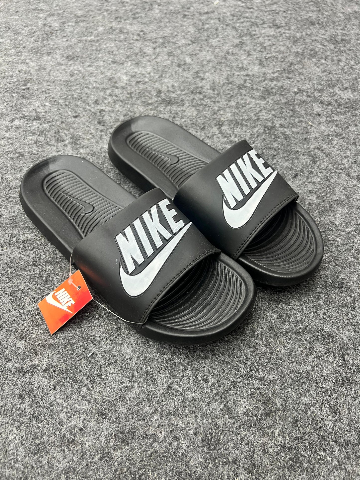 bold white logo for a sharp black Nike slides